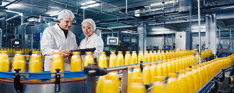 Bottelen van sinaasappelsap in een drankfabriek